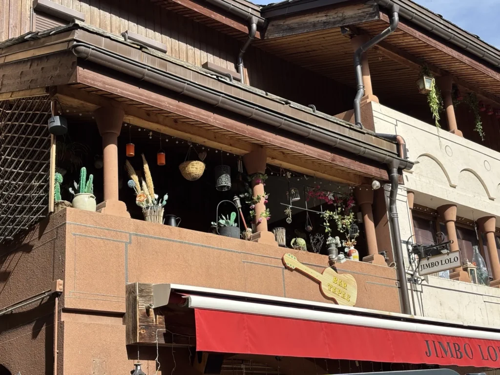 Balcons en bois et façade d’un commerce du Bourg