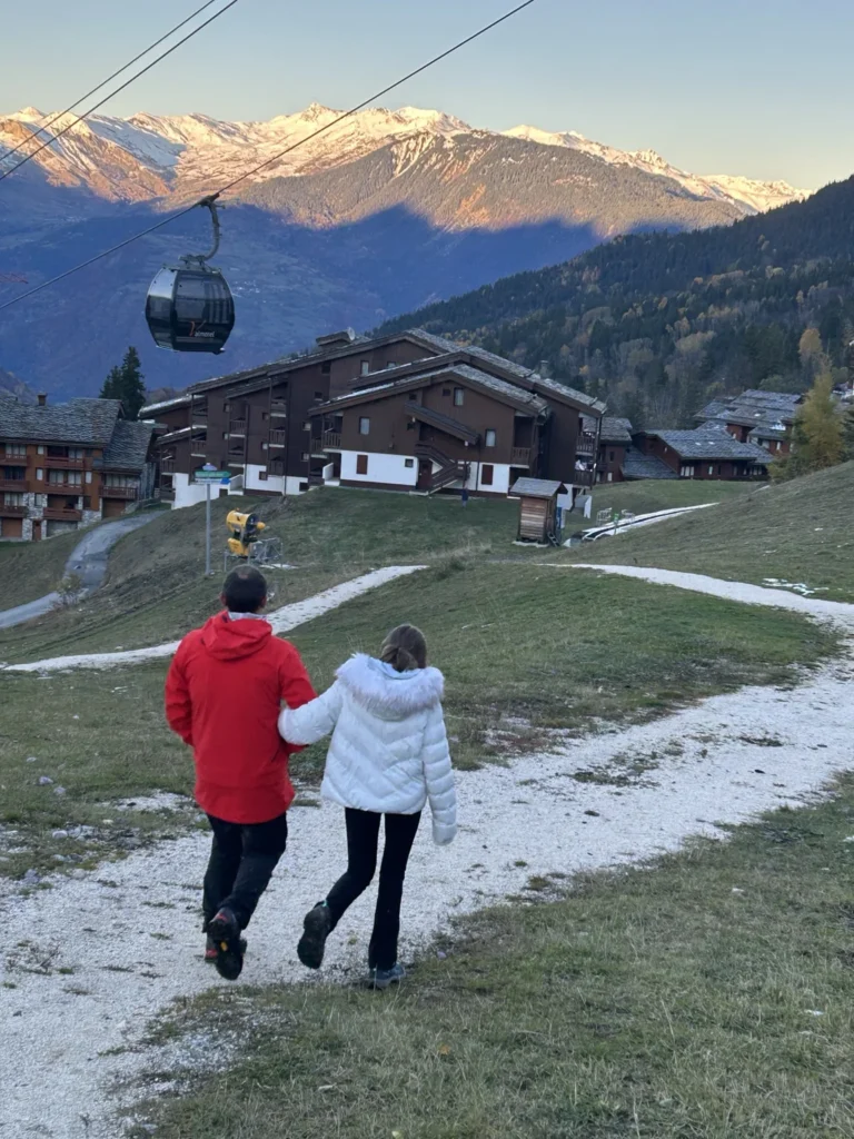 Promeneurs devant les chalets et les premières traces de neige