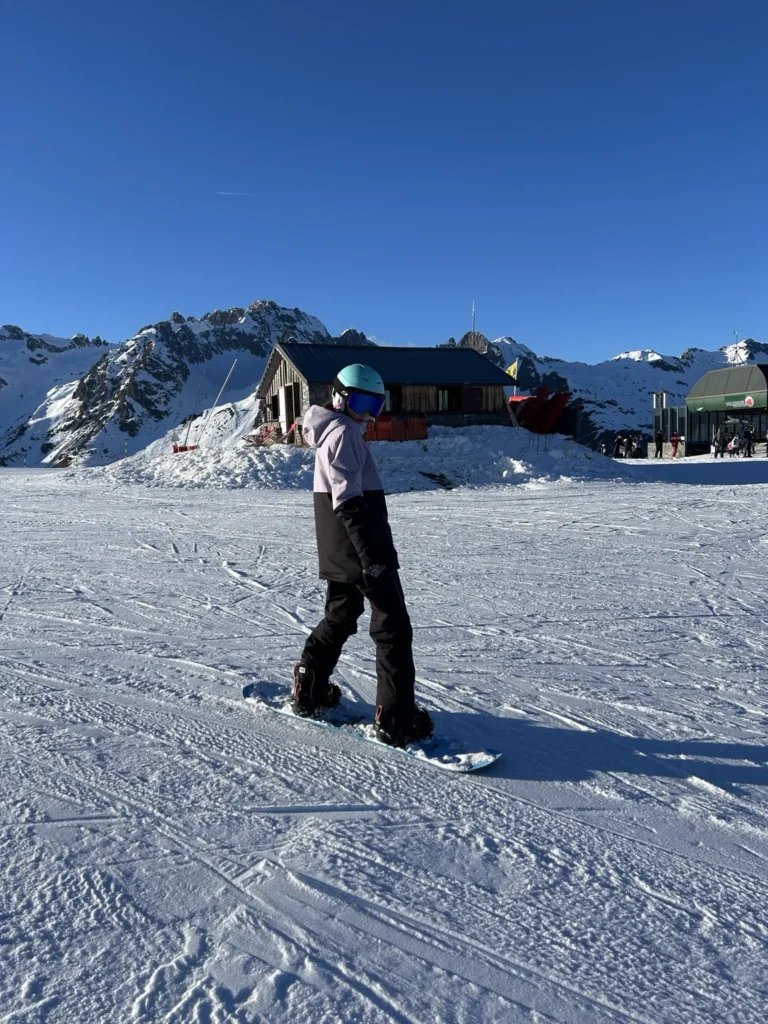 Skieuse sur une piste près des chalets